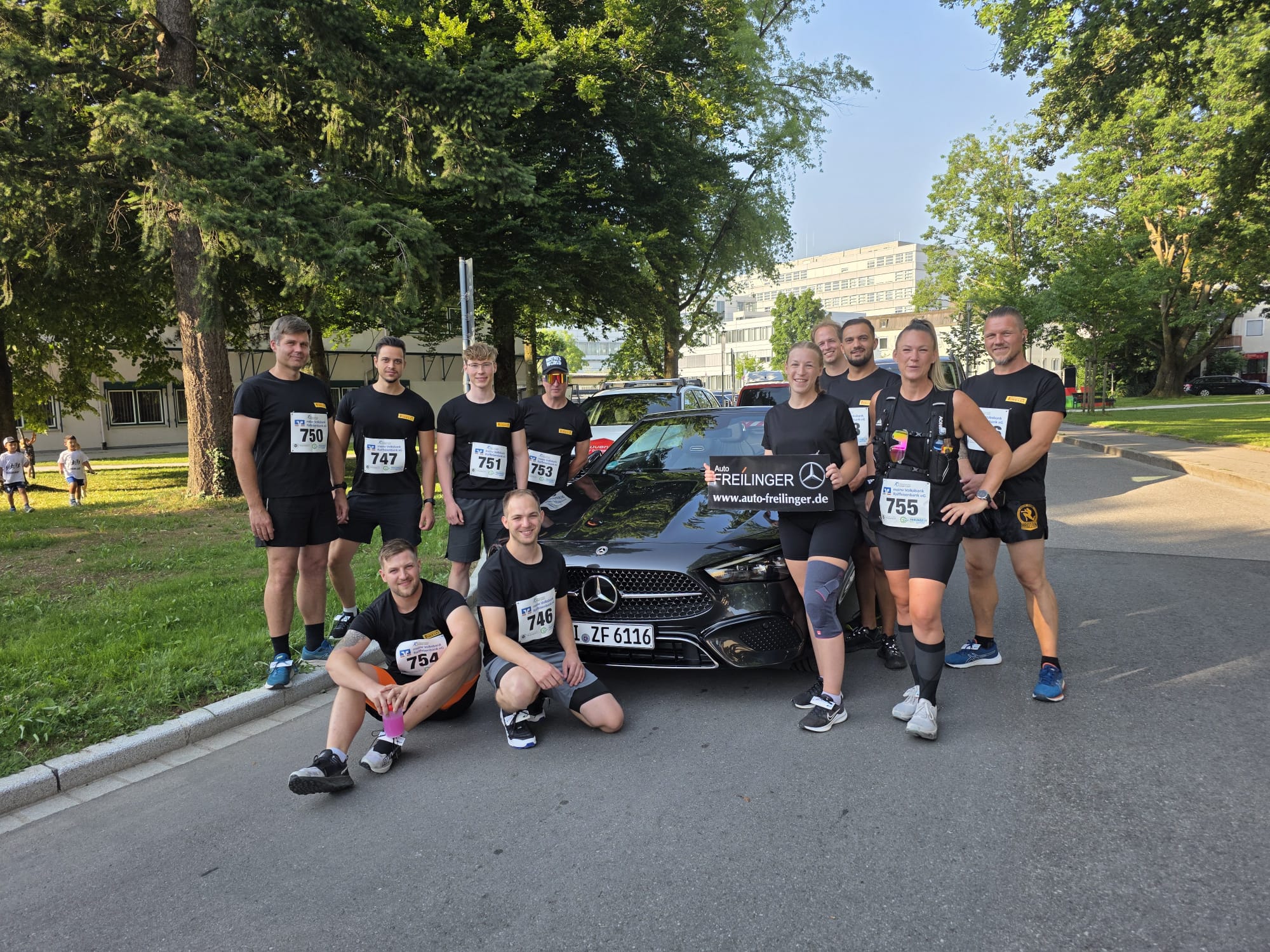 Gruppenbild der Teilnehmer des Traunreuter Stadtlauf 2025 mit einem Mercedes.
